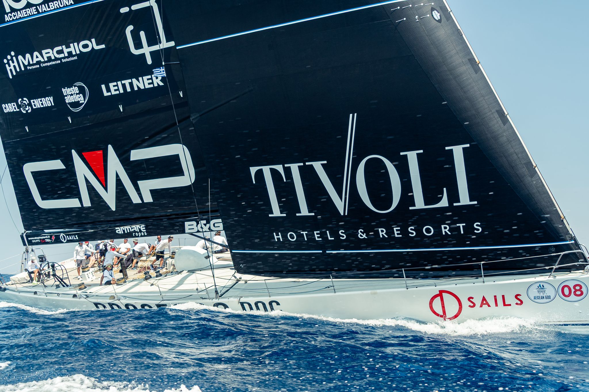 Il maxi yacht Prosecco DOC di bolina, con le vele nere e l’equipaggio in pozzetto